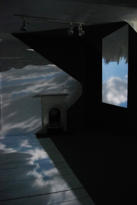Projection of a film onto the walls of Kate's studio space showing clouds and buildings