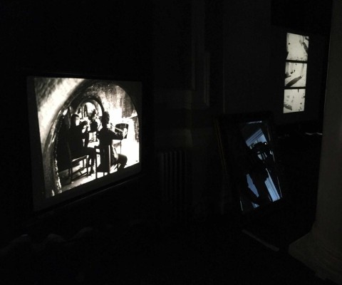 Film projection showing musicians seated underneath the archways of Sunny Sands Beach, Folkestone