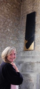 Gold leaf-painted wall-mounted oak panel in situ of the church interior with smiling commissioner Diana Baldwin.