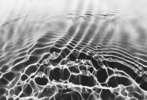 Black and white photogram of the inverted shadow of water ripples