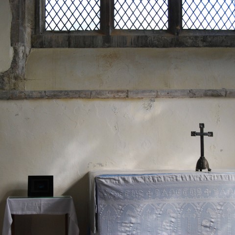 East Spring Birth film situated in the Church interior next to a table with brass crucifix