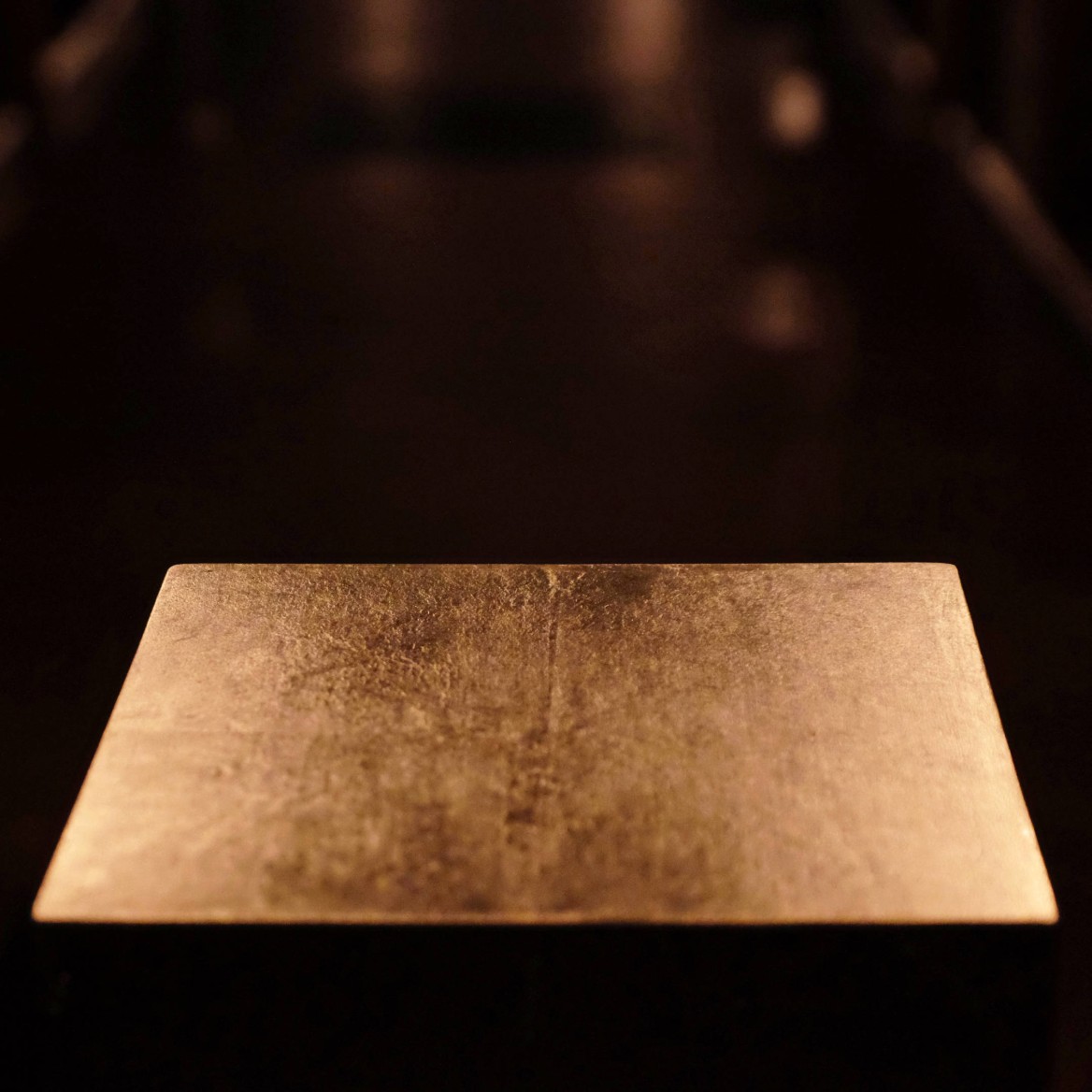 Close-up photo shows the top of a golden cube illuminated by the interior lights of the church