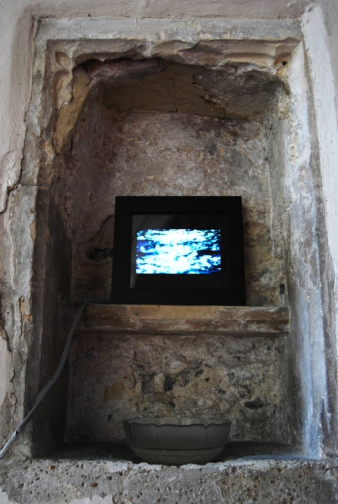 Close-up photo of the South Summer Life film playing within a black-bordered picture frame, resting in an alcove