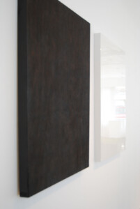 Side view of two rectangle panels, one on the left is burnt black, the one on the right is sprayed white