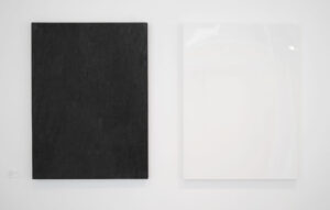 Two rectangle panels, one on the left is burnt black, the one on the right is sprayed white