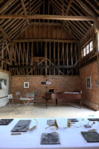 View of interior of barn space with exhibition on the brick walls and on a table in the foreground