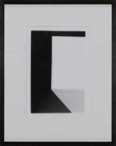 A black, wooded frame surrounds the white mounted piece which depicts the edge of a white cube who's pale grey shadow goes away from the bottom of the square towards the right hand corner. The work has a white border and the artist's signature and the title of the work can be seen written in pencil at the bottom of the piece.