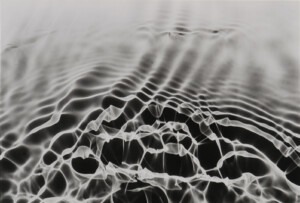 Black and white wave or vibrational patterns, arching across the horizontally rectangle piece, depicting wave-like patterns dissipating into the paler distance.